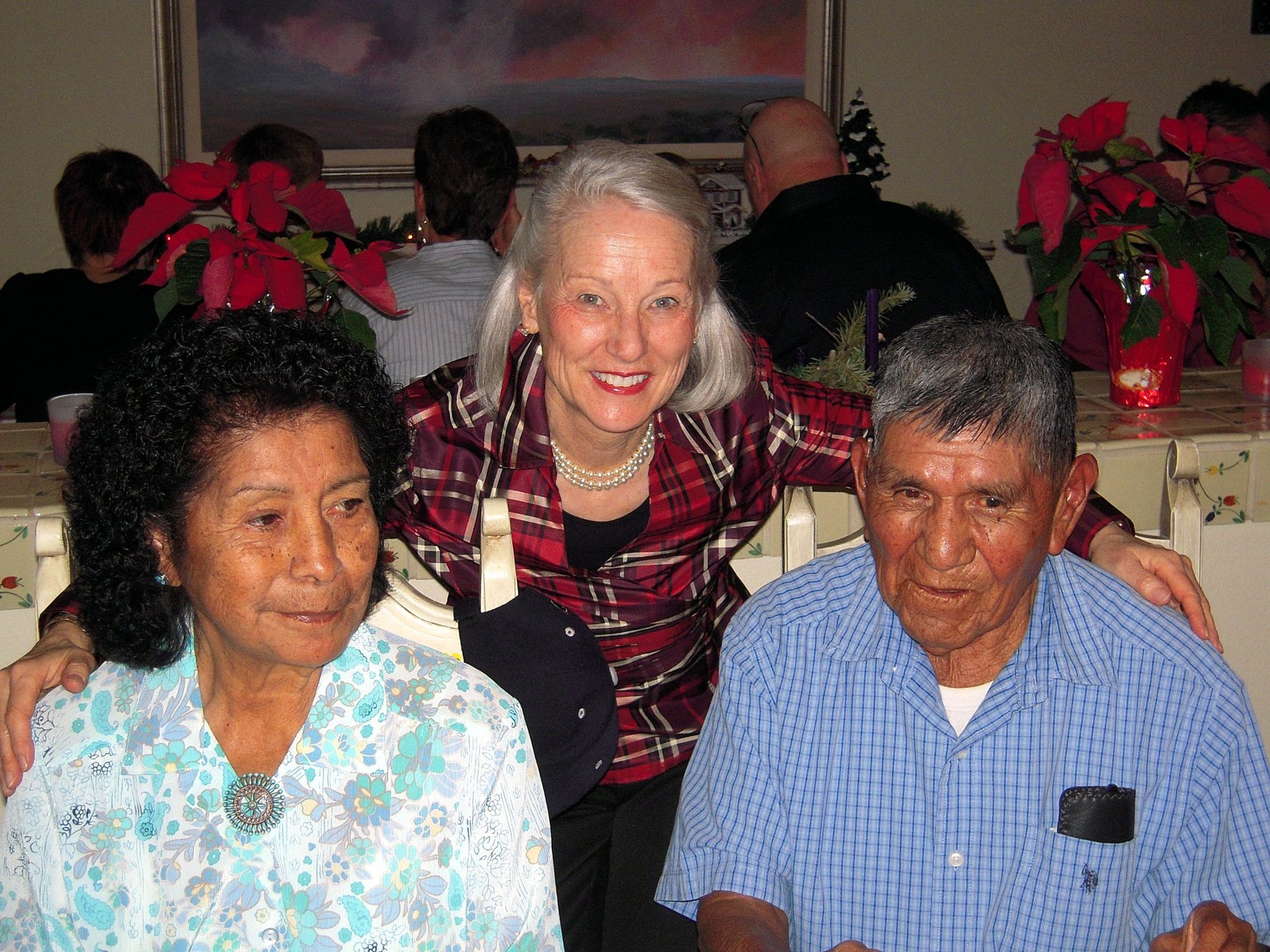 Zuni Annabelle and Paul Peynetsa seated at a holiday gathering, with Judith Kennedy Lavender standing behind them